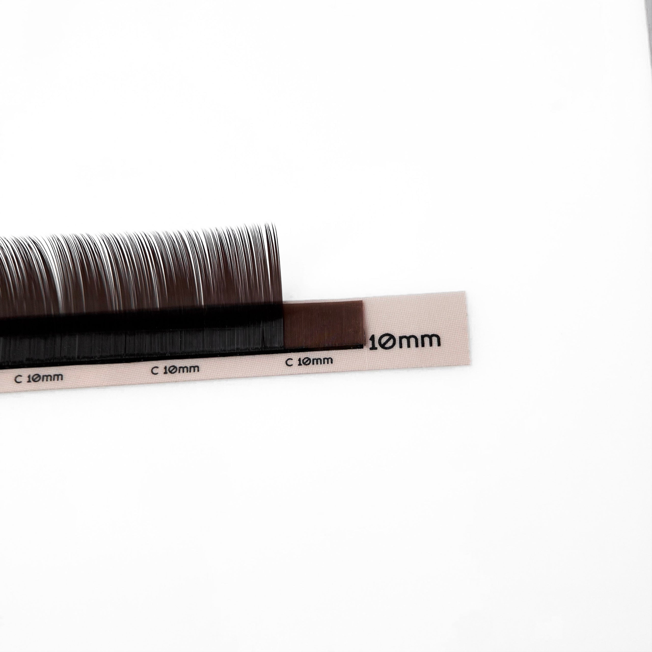 Black Brown Wimpernextensions auf C-Curl Streifen 10 mm – EngelsWimpern®

Das Bild zeigt die EngelsWimpern® Black Brown Wimpernextensions auf dem C-Curl Streifen mit 10 mm Länge. Die Fasern haben eine dunkelbraune Tiefe mit leicht schwarzem Schimmer, was eine natürlich definierte Wirkung auf helle oder mittelhelle Typen erzielt.