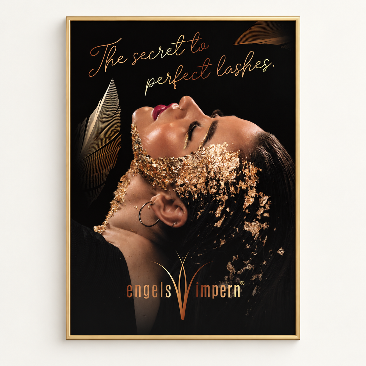 EngelsWimpern Studio-Plakat GOLDEN WOMAN mit golden geschmücktem Beauty-Porträt auf schwarzem Hintergrund und Schriftzug The secret to perfect lashes.